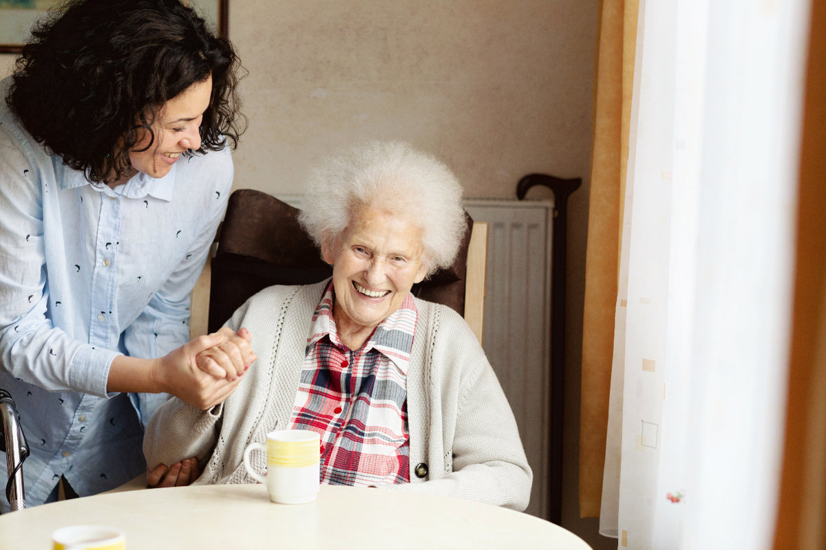 Latin caregiver helping an elderly woman